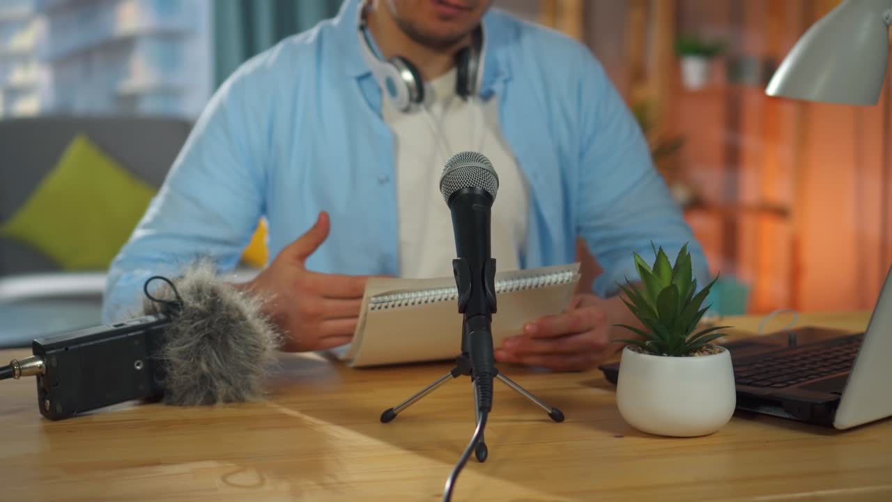 An unrecognizable person records an audio podcast or conducts an Internet stream while sitting in the living room