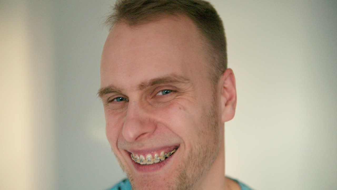 Close up of man's face smiling heavily in slow motion