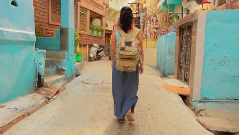 female tourist walks through the streets of an indian city. rajasthan, indian jodhpur also blue city