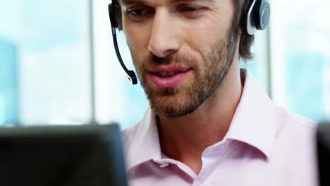 Male-customer-service-executive-working-at-his-desk