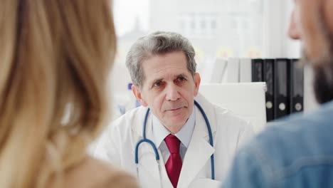 un médico maduro consultando el pronóstico con los pacientes