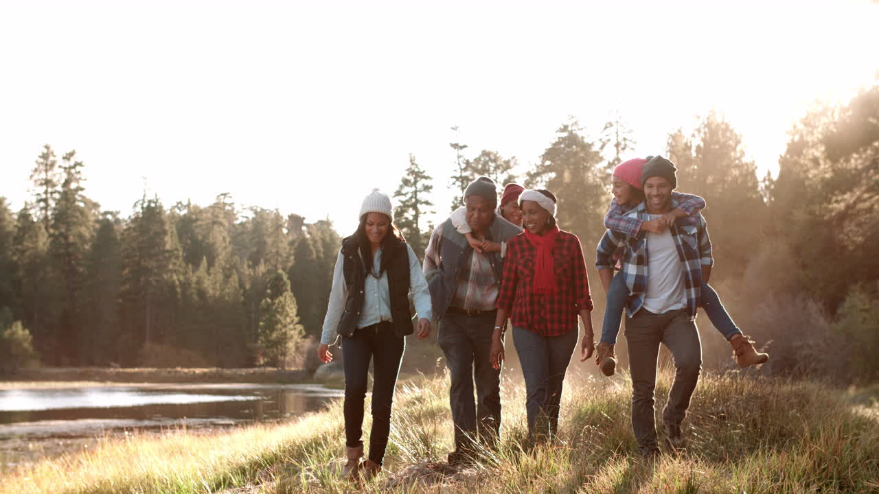 familia de varias generaciones caminando hacia la cámara cerca del lago
