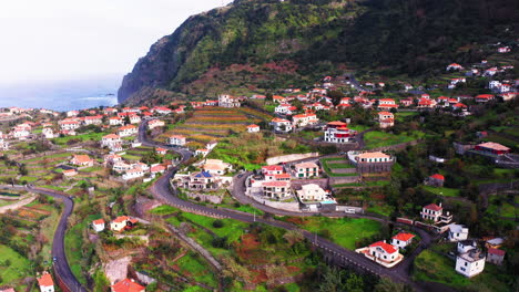 low aerial shot of ponta delgada with houses and apartments surrounded by green grass fields and roads