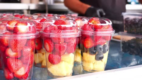 fresh fruit salad cups display at a market