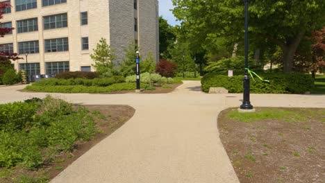 student walking on university college campus with beautiful landscaping