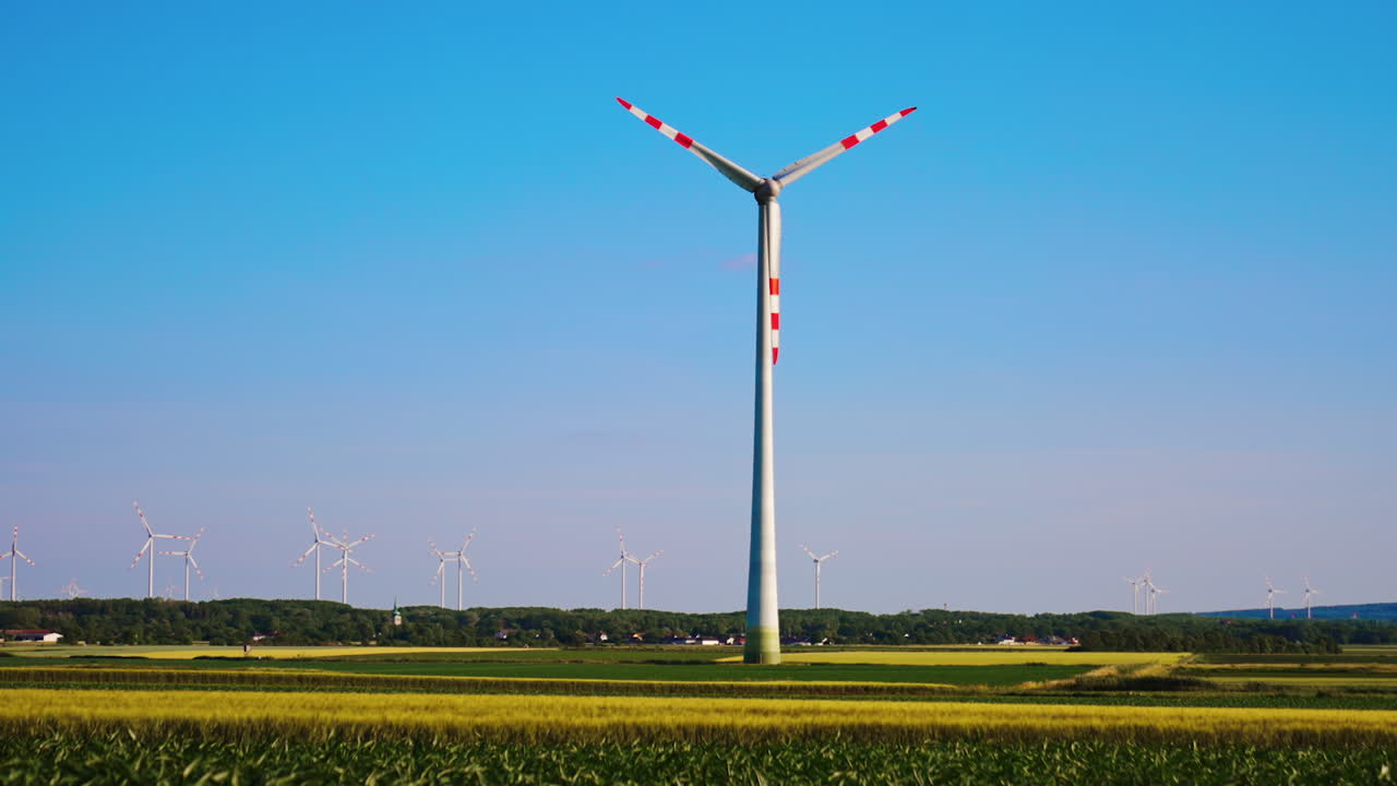 Huge wind turbine working in the field. Wind farm produces the clean energy. Low angle view.