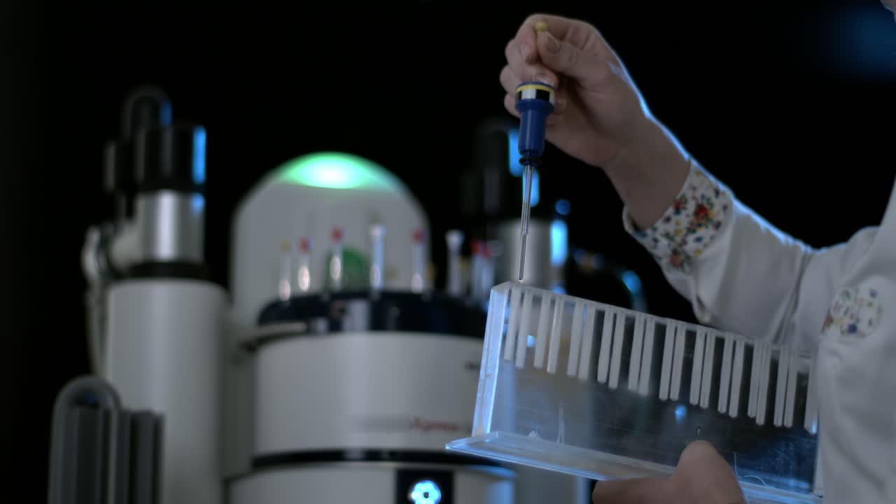 científico que utiliza un sistema robótico de manipulación de líquidos