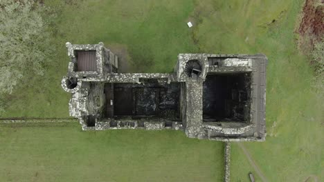 Aerial-view-of-Carnasserie-Castle-ruins-on-an-overcast-day-in-Argyll-and-Bute,-Scotland