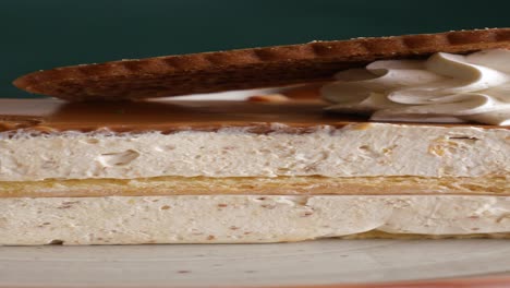 close-up of a delicious caramel cake with whipped cream and cookie on top