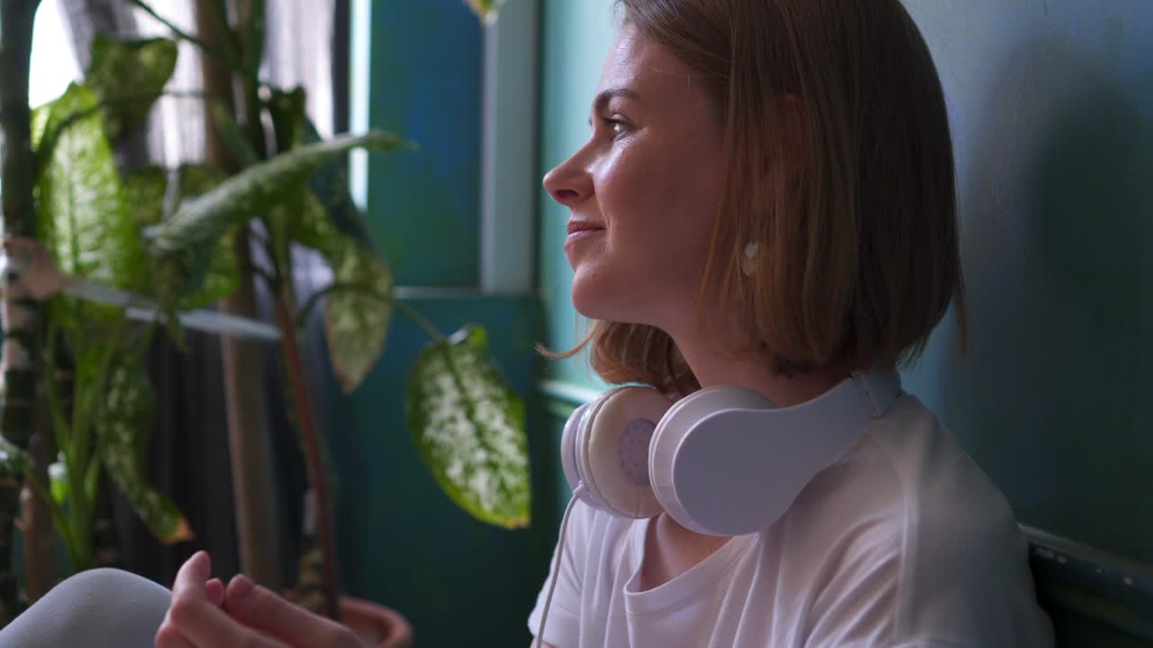 chica relajada disfrutando de la música en los auriculares en el suelo