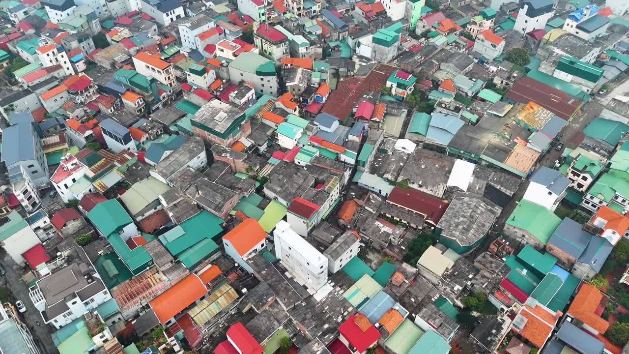 Aerial view of Bat Trang pottery village on the outskirts of Hanoi, Vietnam, showcasing a densely packed urban area with colorful rooftops and narrow streets.
