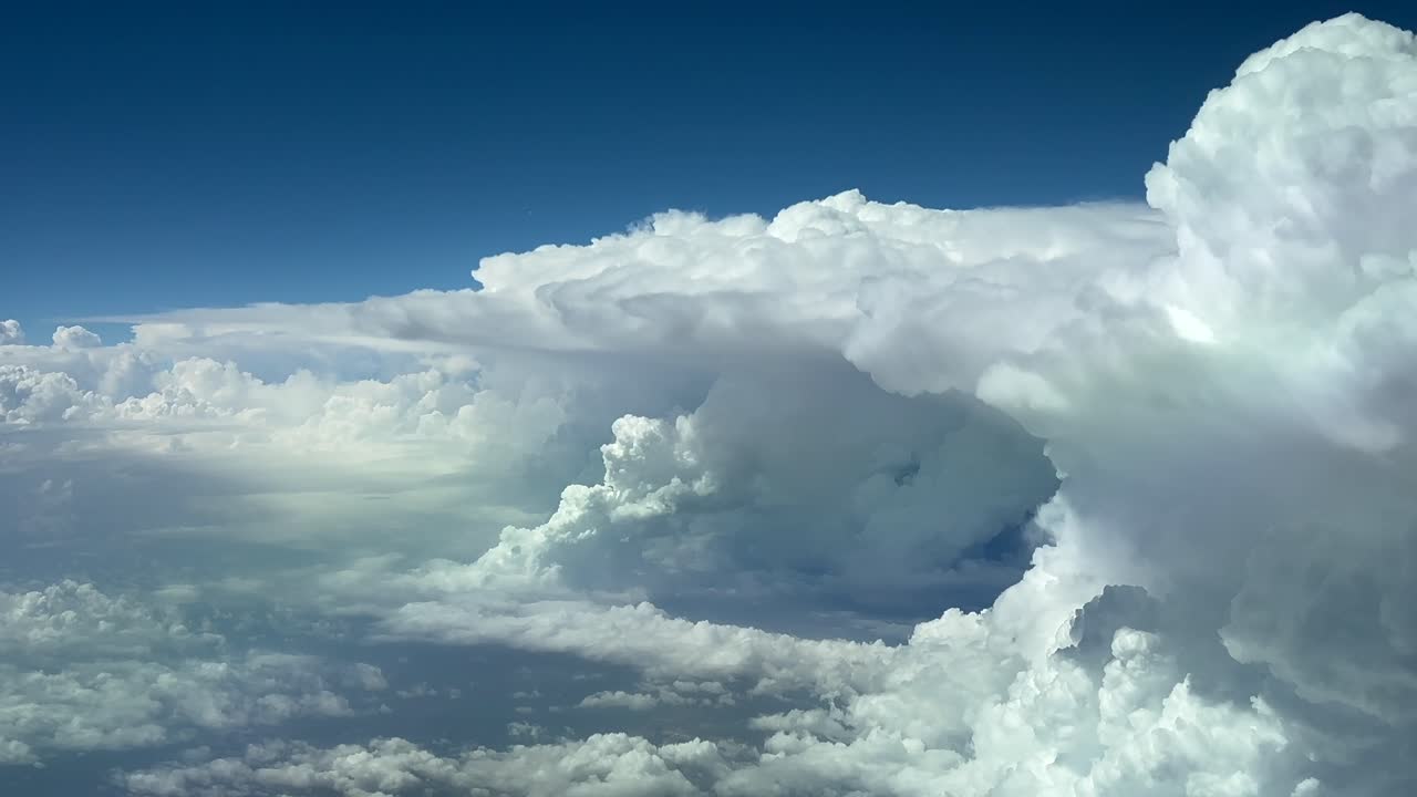 Massive storm clouds seen from above the sky: an unique pilot’s perspective from a jet cockpit flying across a turbulent sky. 4K