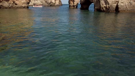 Inclinándose-Desde-El-Agua-De-Mar-Hasta-Las-Formaciones-Rocosas-Cuando-El-Barco-Pasa-Por-Ponta-Da-Piedade,-Lagos,-Portugal