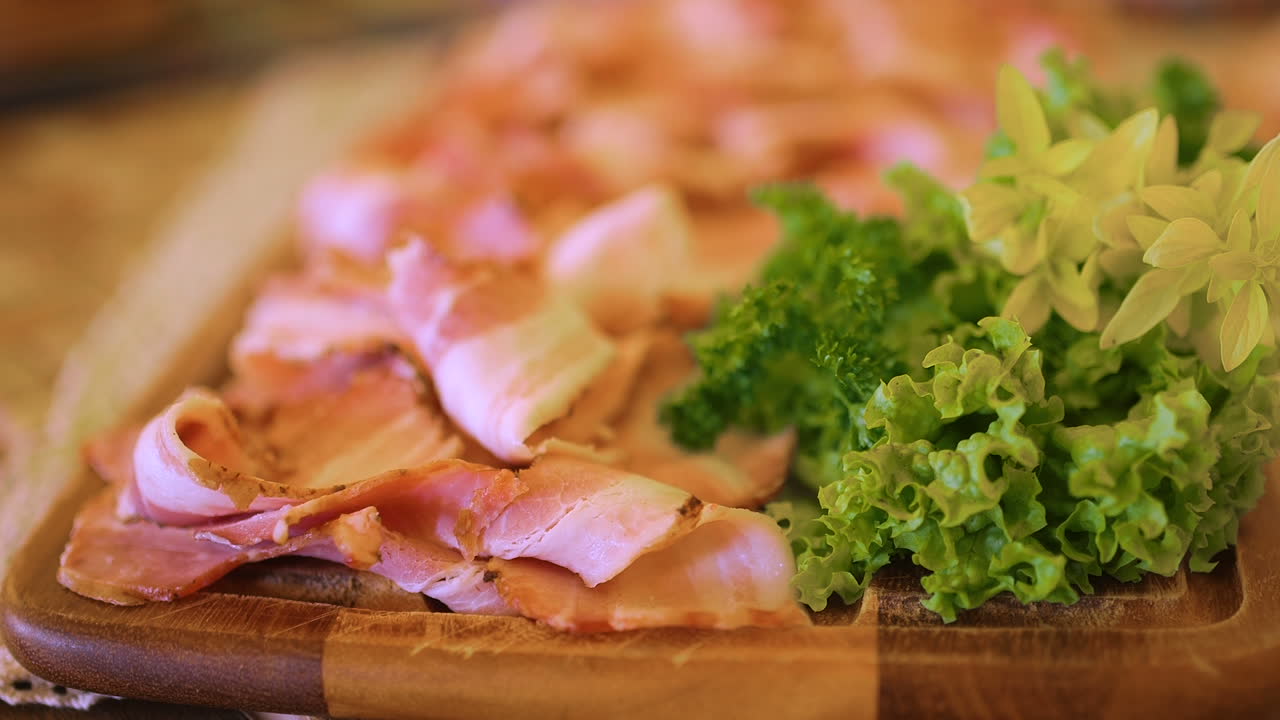 Salumi affettati con lattuga fresca e prezzemolo su tagliere di legno