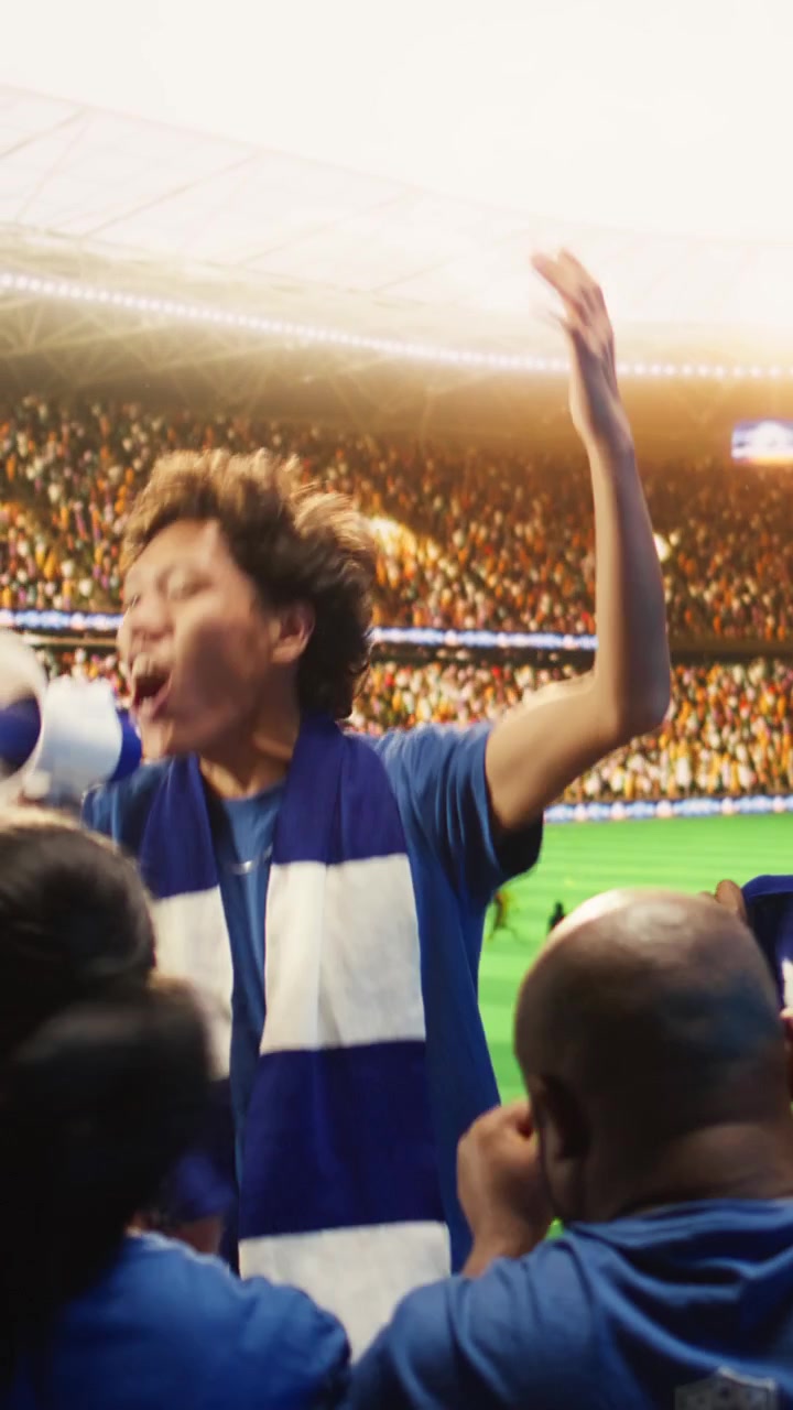 Video vertical: Hombre fanático en estadio de fútbol gritando con megáfono, animando a los jugadores