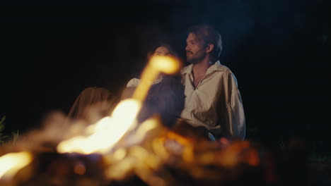 couple enjoying a romantic campfire at night