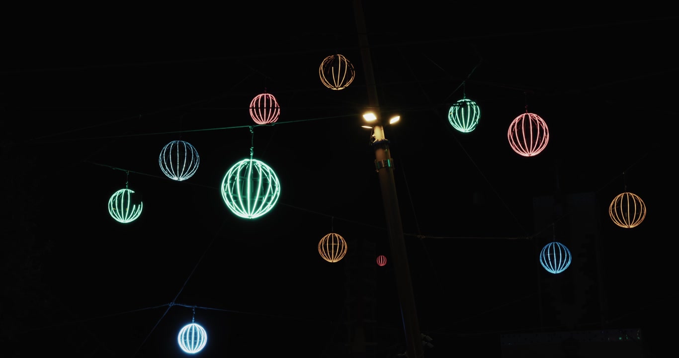 Lampu bulat gantung berwarna cerah menerangi langit malam di Prater Wina.