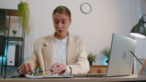 Business-smiling-woman-closing-laptop-computer-after-finishing-online-work-remote-job-from-office