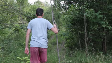 a man walks on a footpath in forest, daytime, summer season