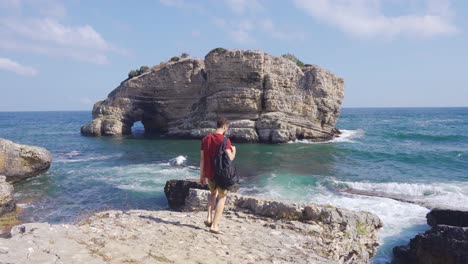 man walking towards sea cliff.