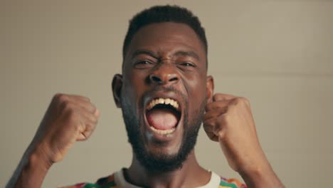 Close-Up-Portrait-Of-Afro-American-Man-Excitingly-Celebrating-In-Slow-Motion