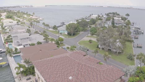 Porsche-luxury-sports-car-drives-through-St-Pete-waterfront-villas-area,-aerial