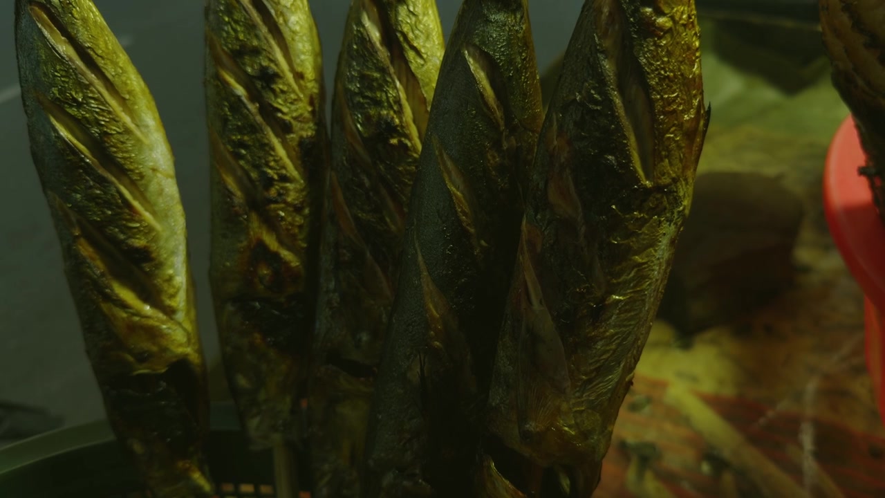 Primo piano di spiedini di pesce grigliati in un mercato notturno