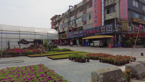 escena callejera ocupada en la ciudad asiática con mercado de plantas y tiendas