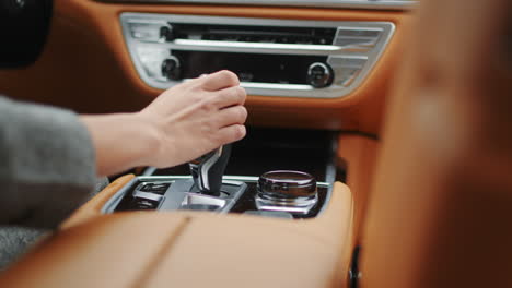 Mano-De-Mujer-De-Primer-Plano-Manteniendo-El-Engranaje-Automático-En-El-Coche.-Mano-Femenina-Cambiando-De-Marcha