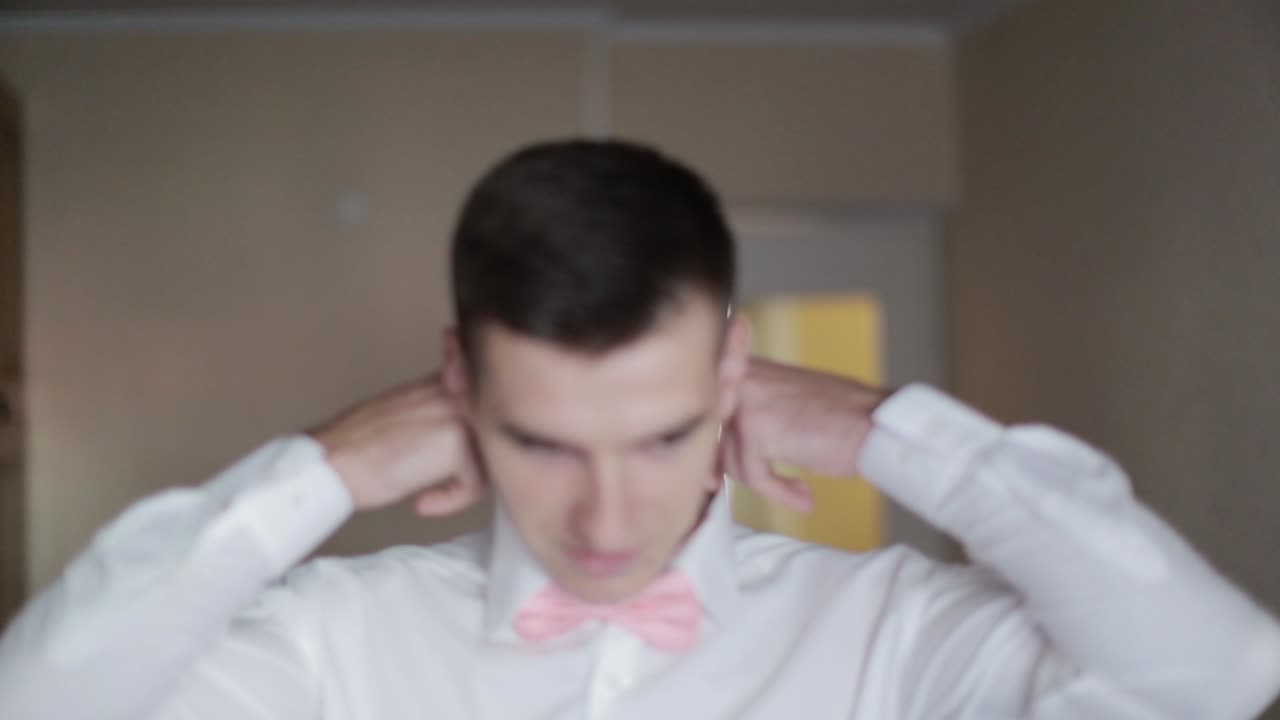 Groom Morning Preparation Details. Elegant groom wearing white shirt and bow tie