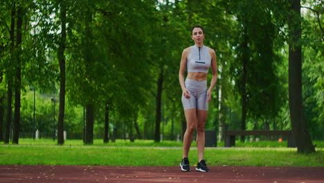 atleta femenina realiza estocadas laterales trabajar sus piernas y saltar en el parque en cámara lenta. mujer hermosa jugando deportes en el parque.