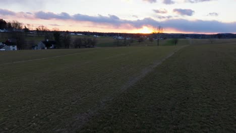 low aerial glide over bare field in winter