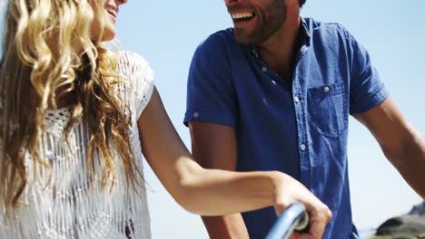 Couple-riding-bicycle-at-beach