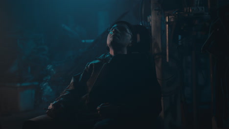 mysterious man in the workshop at night smokes a cigarette