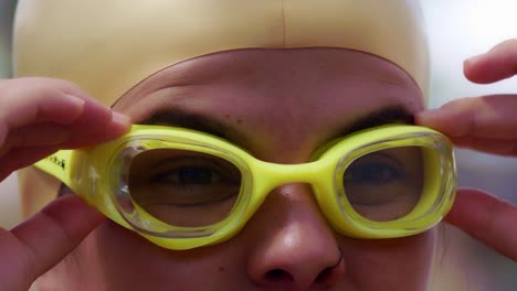 atractiva nadadora hispana se pone las gafas para prepararse para nadar