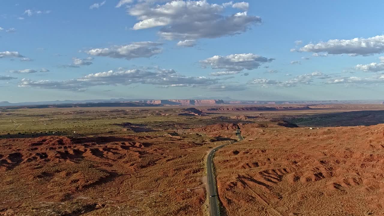 Road winding through a vast red rock desert landscape