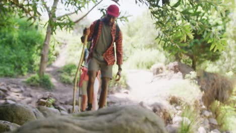 Happy-diverse-couple-hiking-with-backpacks-in-park,-slow-motion