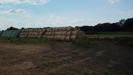 Flight-backwards-over-an-abandoned-trailer-and-bales-in-the-in-the-middle-of-a-field