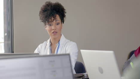 Diverse-doctors-using-laptops-in-meeting-room-with-copy-space,-slow-motion