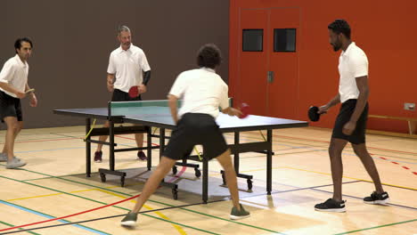 playing table tennis, men high-fiving and walking in indoor sports hall