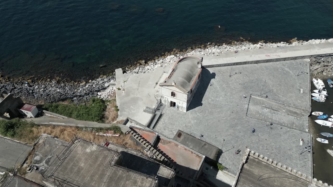drone aéreo de arriba hacia abajo filmado volando alto sobre una antigua iglesia junto al lago tekapo, pozzuoli, italia en un brillante día soleado