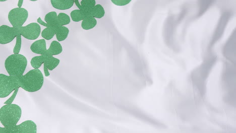 green shamrocks animation over white fabric background