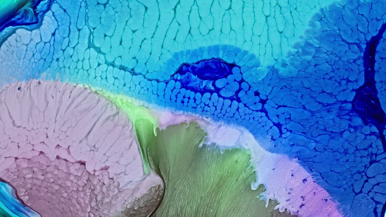 생동감 넘치는 파란색과 초록색 잉크가 물에 퍼져 추상적인 패턴을 만니다.