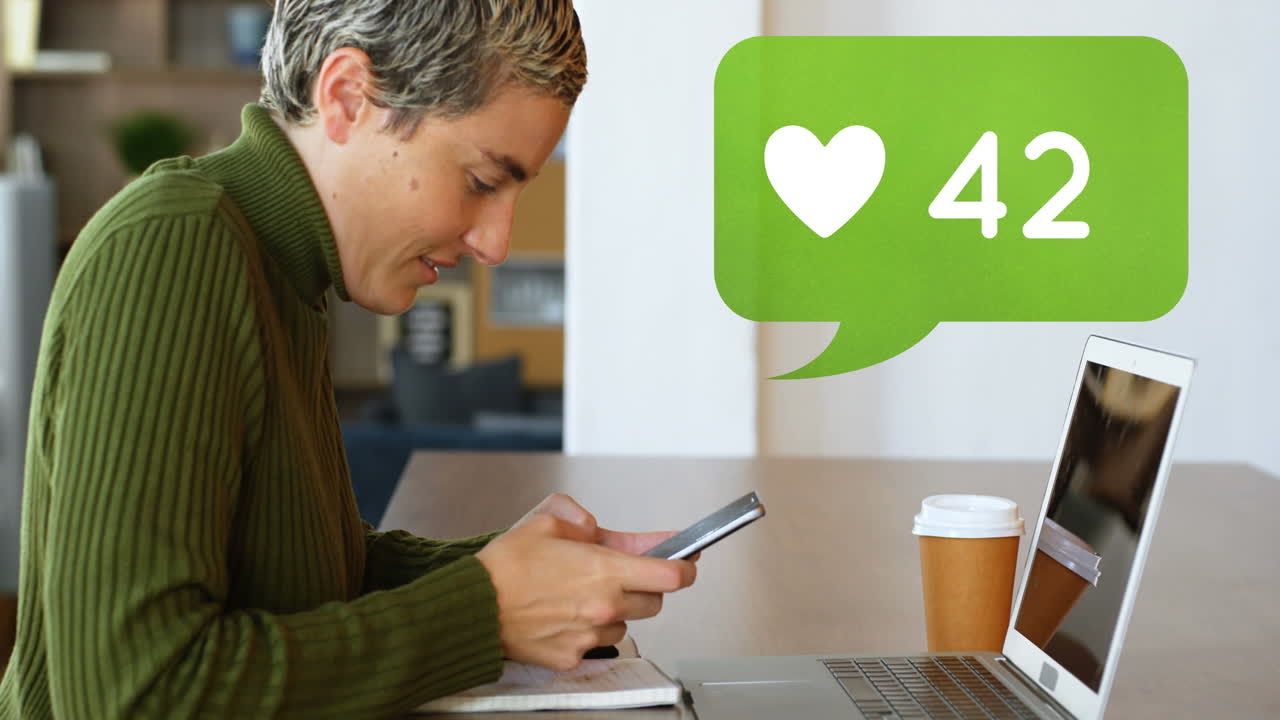 mujer enviando mensajes de texto en su teléfono frente a su portátil 4k