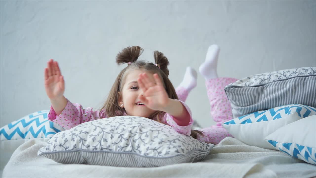 Happy Child Lying on Pillows in Pajamas