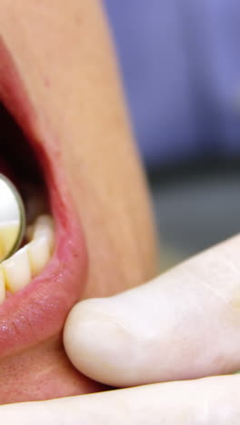 dentista examinando a una paciente con herramientas dentales