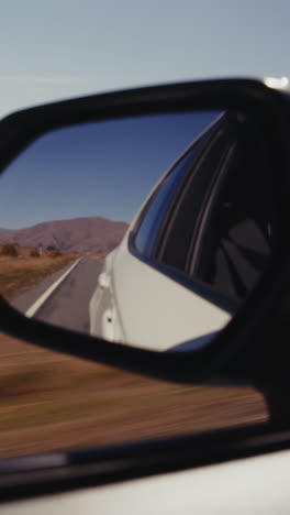 car side mirror view of a country road