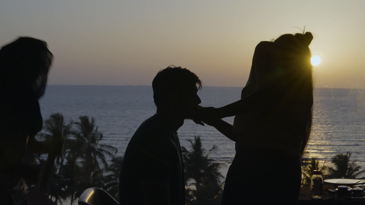 Silhouette of a man in India having makeup and hair done while the sun has almost set