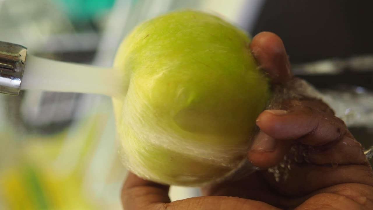 Washing an apple under a tap