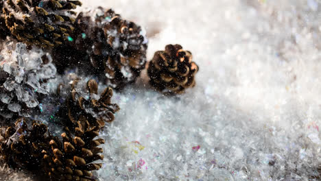 snow falling over multiple pine cones on snow on wooden surface